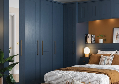 Modern bedroom with navy fitted wardrobes and cosy bed
